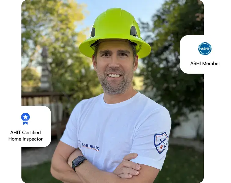 Home inspector outdoors in a bright yellow hard hat; ASHI member and AHIT certified badges visible at sides.